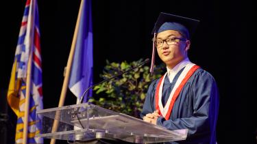 Graduate giving a speech at the podium